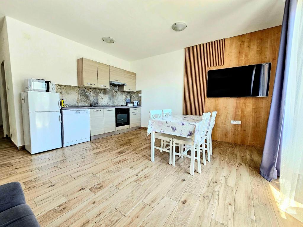 a kitchen with a table and chairs and a kitchen with a refrigerator at Bepo in Zadar