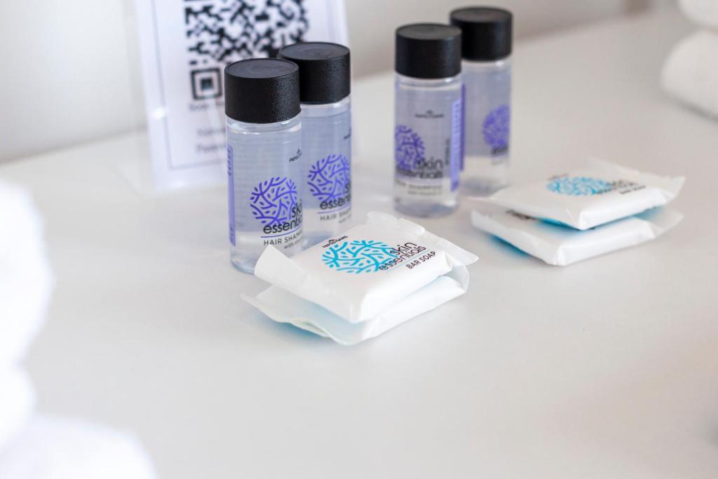 un grupo de cuatro botellas de líquidos sentadas en un mostrador en Ionio Rooms II, en Himare