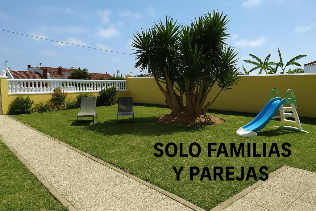 a playground in a yard with chairs and a slide at Casa SUROESTE - Zona El Colorado, Conil de la Frontera in Roche