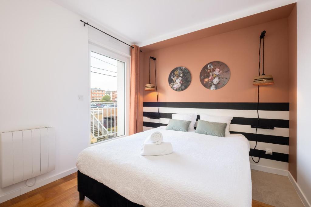 une chambre avec un lit blanc et une fenêtre dans l'établissement Chez Mona L Hyper centre Lens 1 ch, à Lens