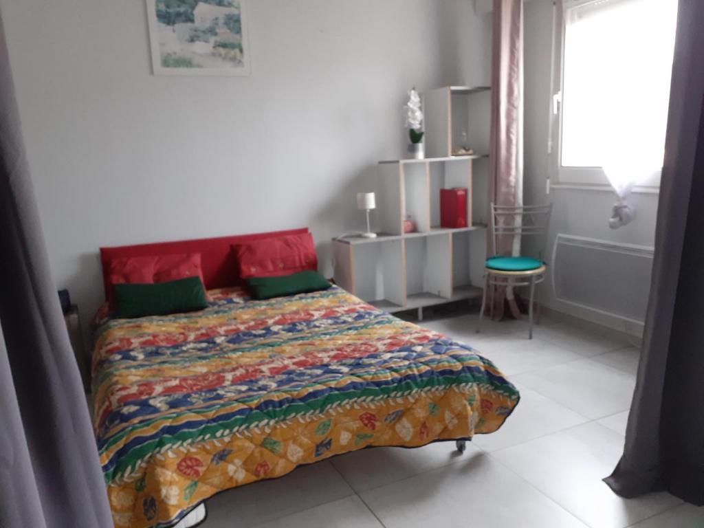 une chambre avec un lit avec une courtepointe colorée dessus dans l'établissement Studio ronce les bains, à La Tremblade