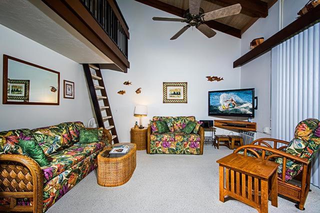 a living room with a couch and chairs and a tv at Kona Makai 3-302 in Kailua-Kona