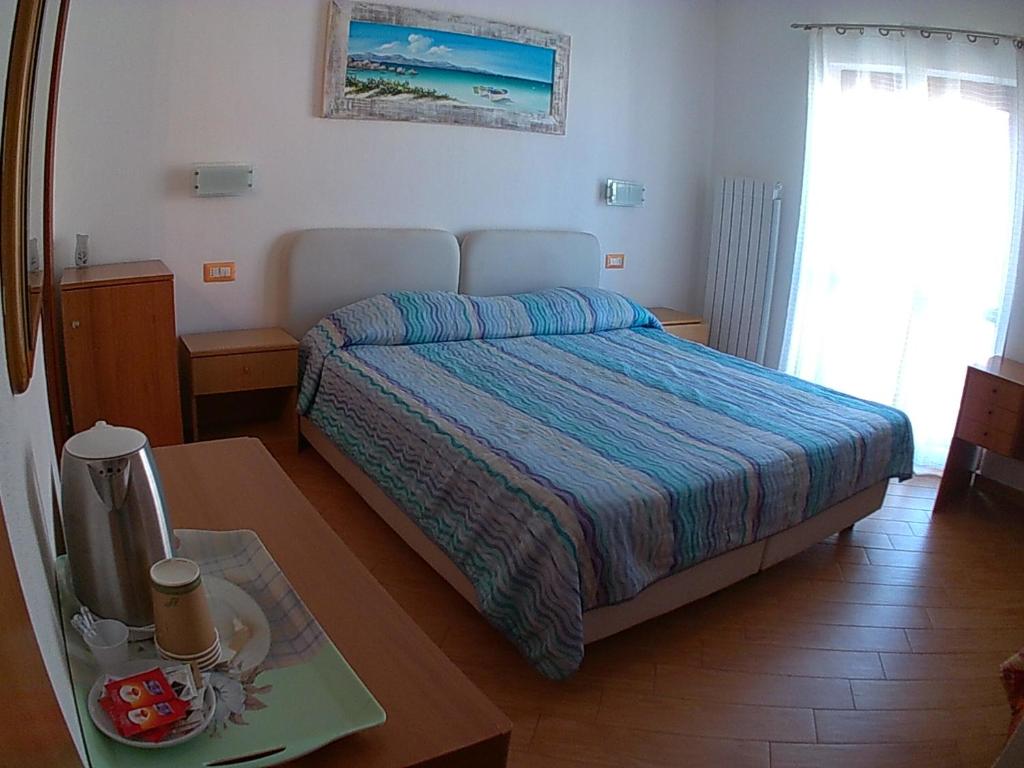 Un dormitorio con una cama y una mesa con bandeja. en Al Martin Pescatore, en Stintino