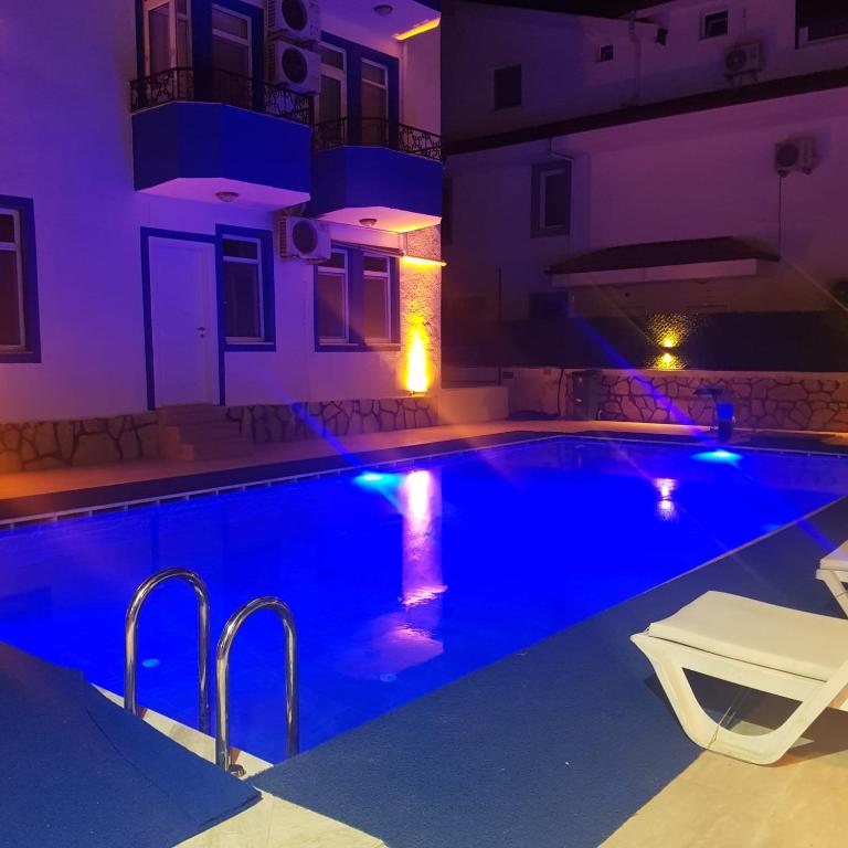 a swimming pool in a house at night at Fethiye Apart Otel in Fethiye