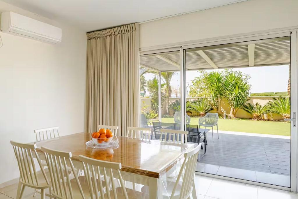 a dining room with a table and chairs and a balcony at GW002 Gugel Waves Amazing Seaview & Garden Family Apartments in Nahariyya