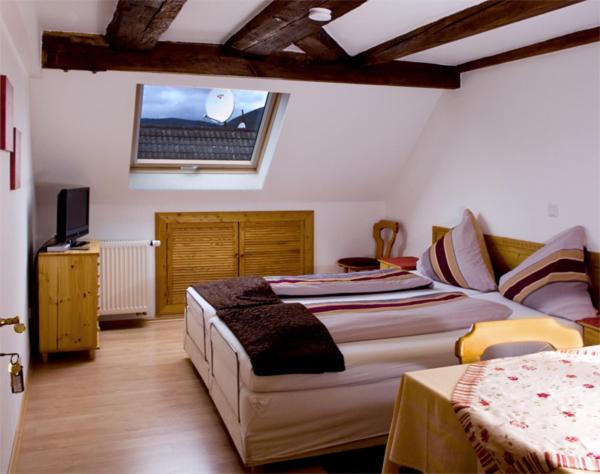 a bedroom with a bed and a couch and a window at Gasthaus Korfu in Edenkoben