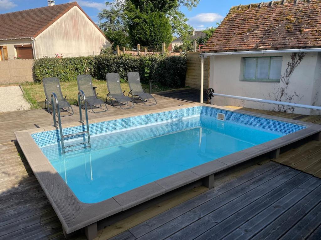 - une piscine entourée de chaises dans l'établissement House Saint Laurent Nouan balneo and pool, à Saint-Laurent-Nouan