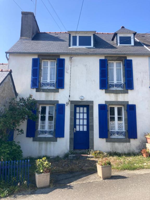 Maison blanche avec volets bleus dans l'établissement Maison artistes bord de mer Rostellec, à Crozon