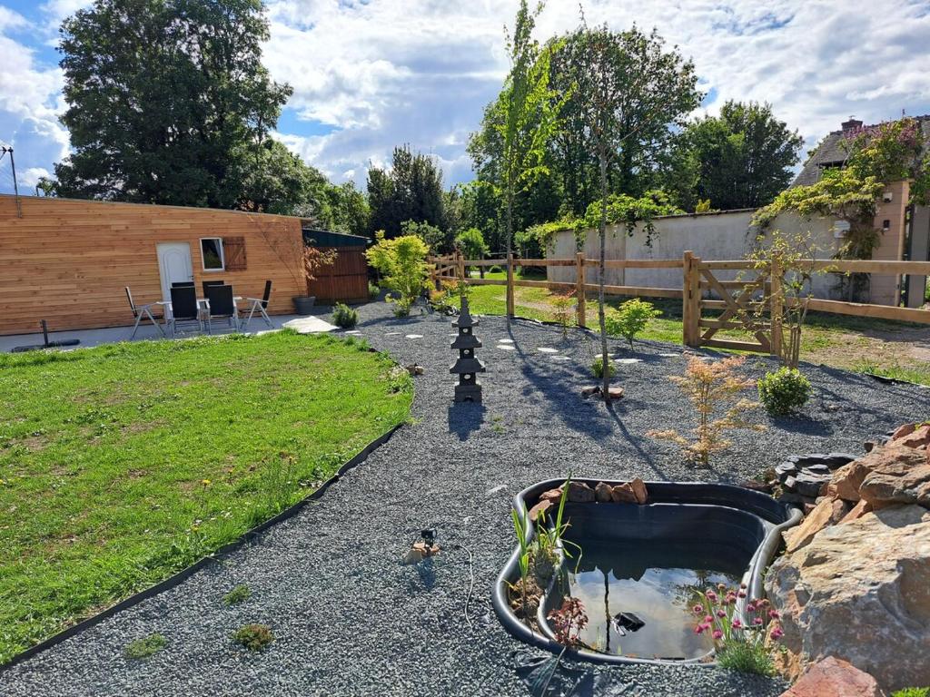 einen Garten mit einem Teich inmitten eines Gartens in der Unterkunft Pause zen dans le Perche Nature & calme 