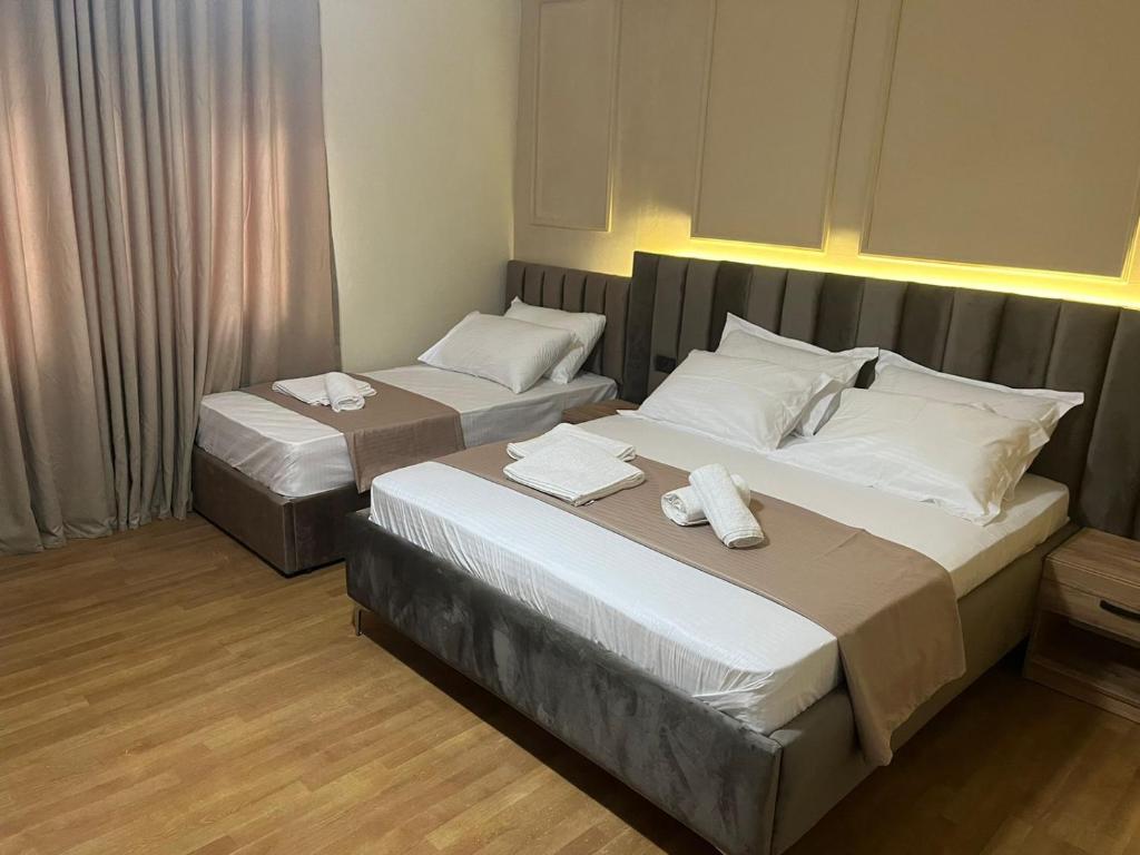 two beds in a hotel room with towels on them at Eriks Rooms in Tirana