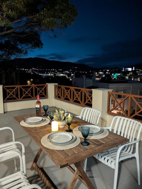 a wooden table with plates and candles on a patio at Casa Carmela in Posidhonía
