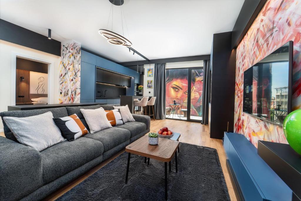 a living room with a couch and a table at Central Paul Deluxe Apartment - by Open House in Timişoara
