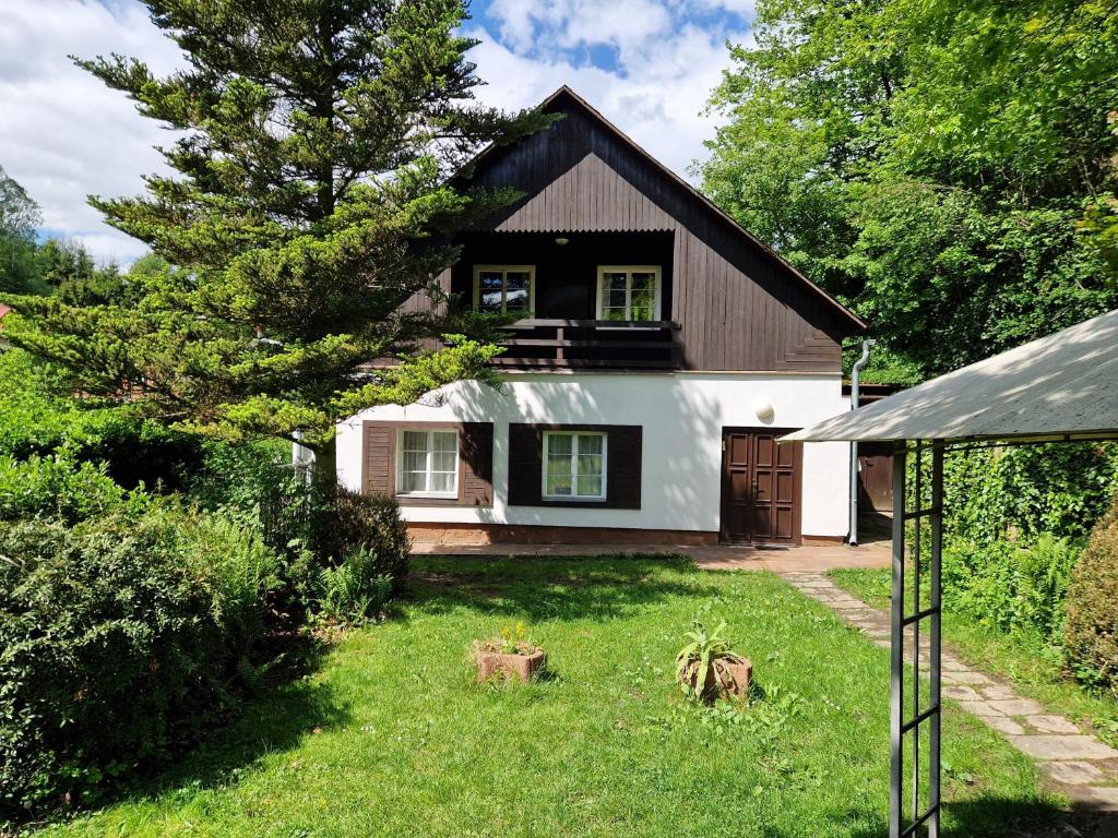 una casa con una casa bianca e nera di Chalupa Hnízdo Jetřichovice a Jetřichovice