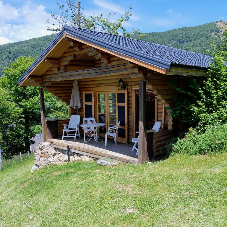 une cabane en rondins avec une table et des chaises sur une terrasse dans l'établissement Chalet de montagne Las Trinquades, à Boussenac