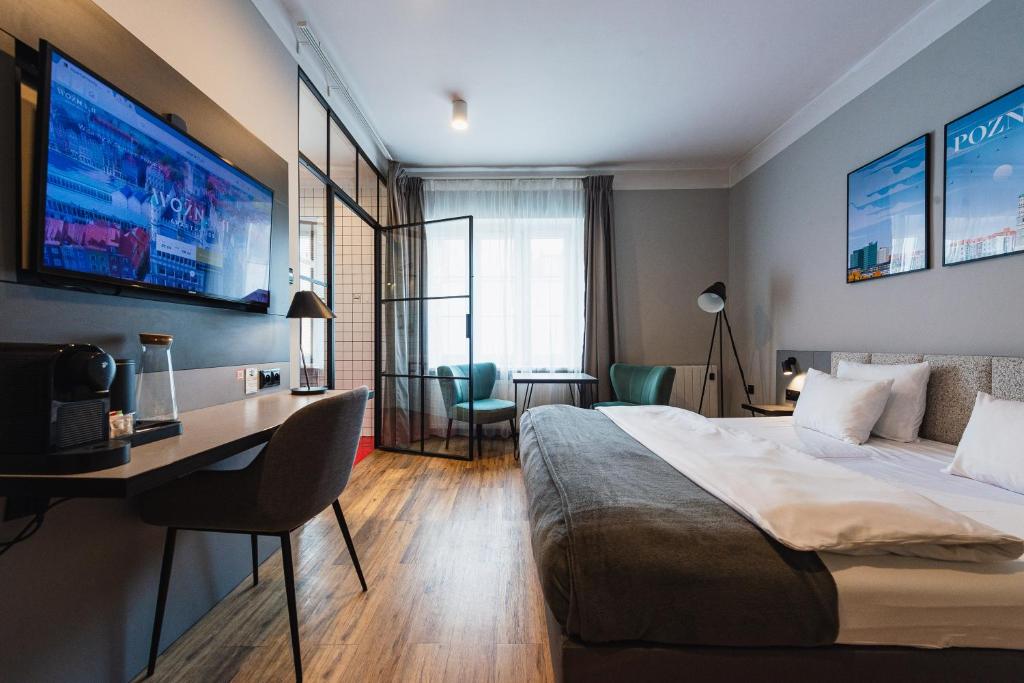 Pokój hotelowy z łóżkiem, biurkiem i telewizorem w obiekcie Stary Rynek Old Market Apartments w Poznaniu
