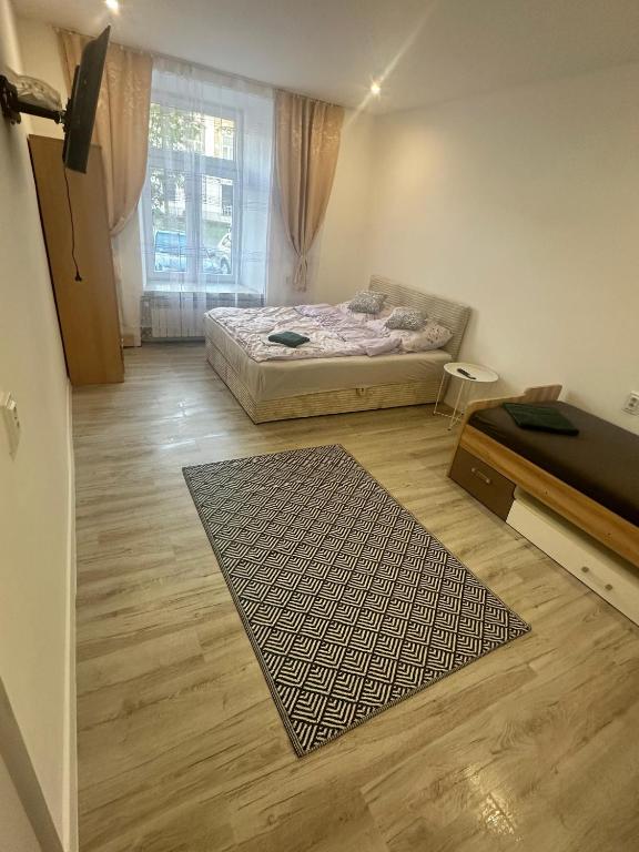 a bedroom with a bed and a rug on a wooden floor at Hostel w samym Centrum Radomia ! in Radom