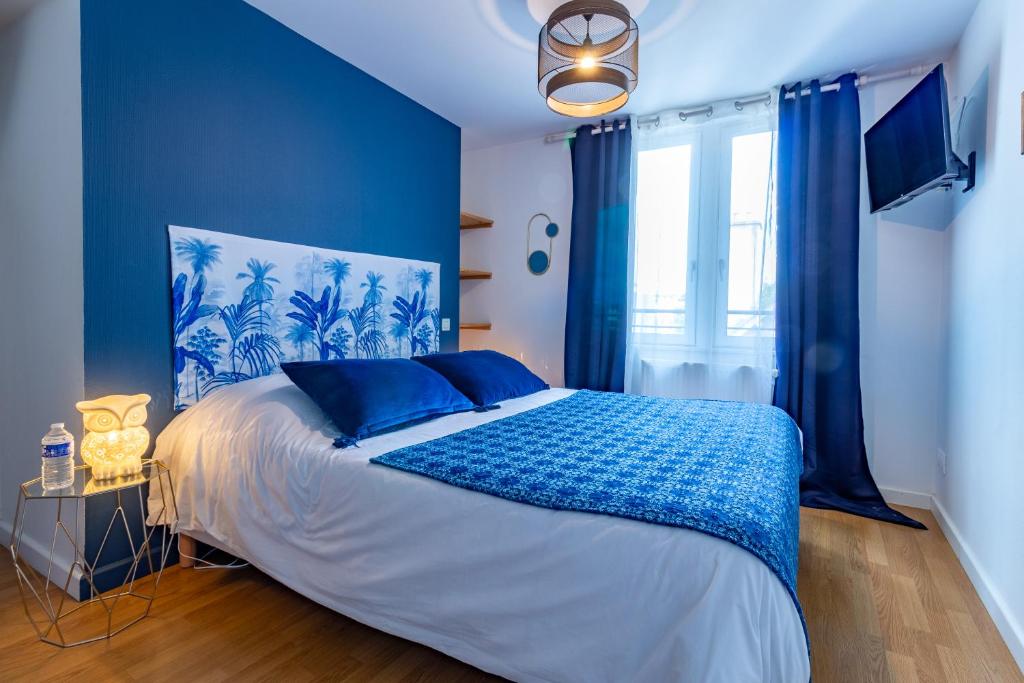 une chambre avec des murs bleus et un lit avec des oreillers bleus dans l'établissement Le Troyes Clochers, à Troyes