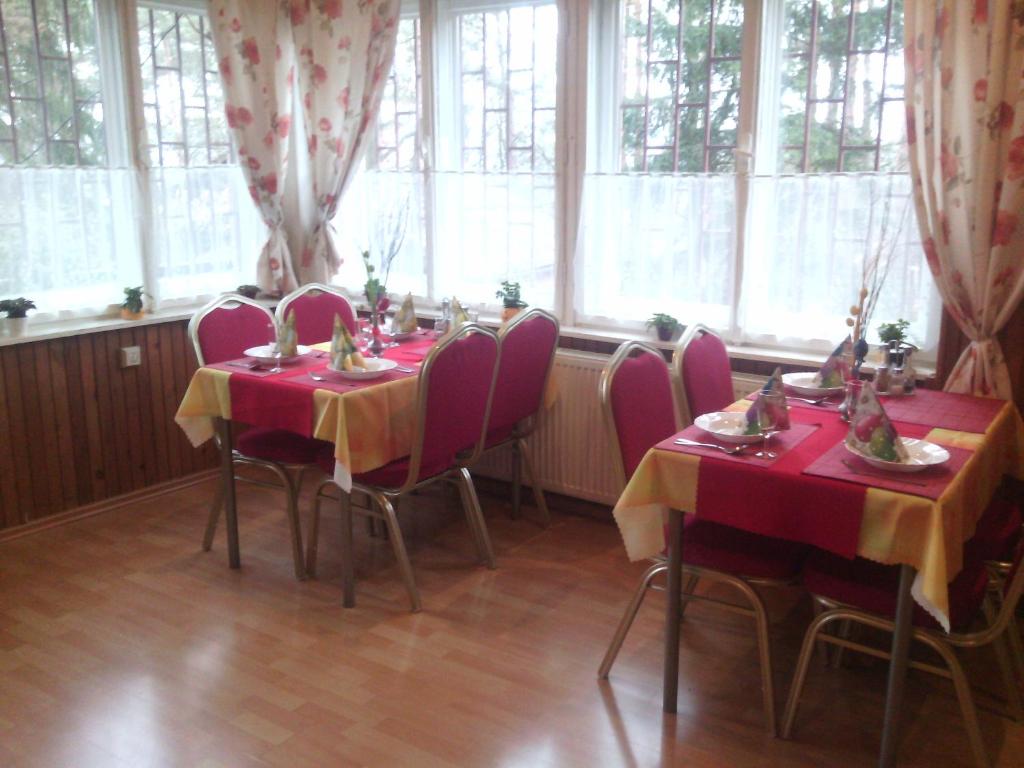 ein Esszimmer mit 2 Tischen und einem roten Tischtuch in der Unterkunft Penzion MIMA V Kováčovej in Kováčová