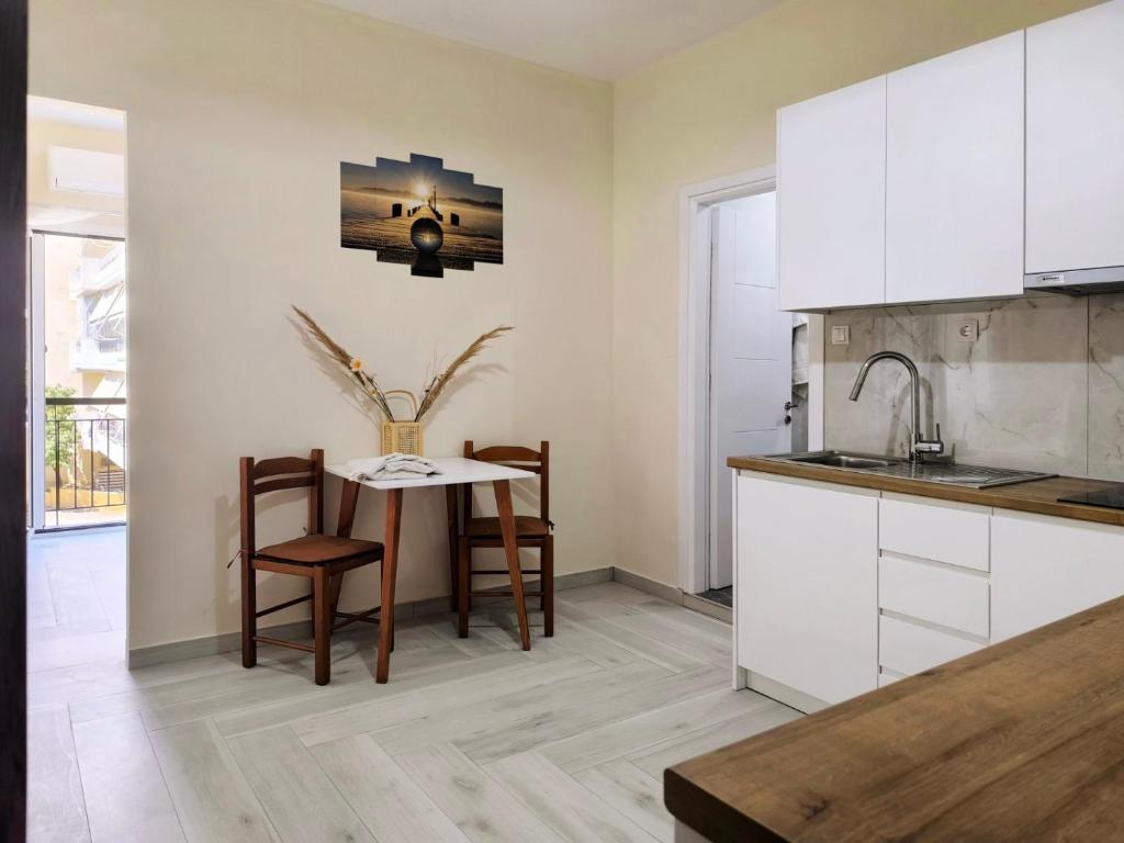 a kitchen with a table and chairs and a sink at Sokrates Apartments in Preveza