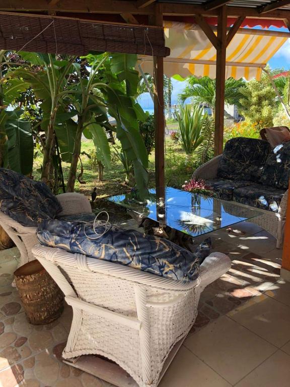 a patio with a glass table and chairs and a pool at la maison des bois flottés in Port-Louis