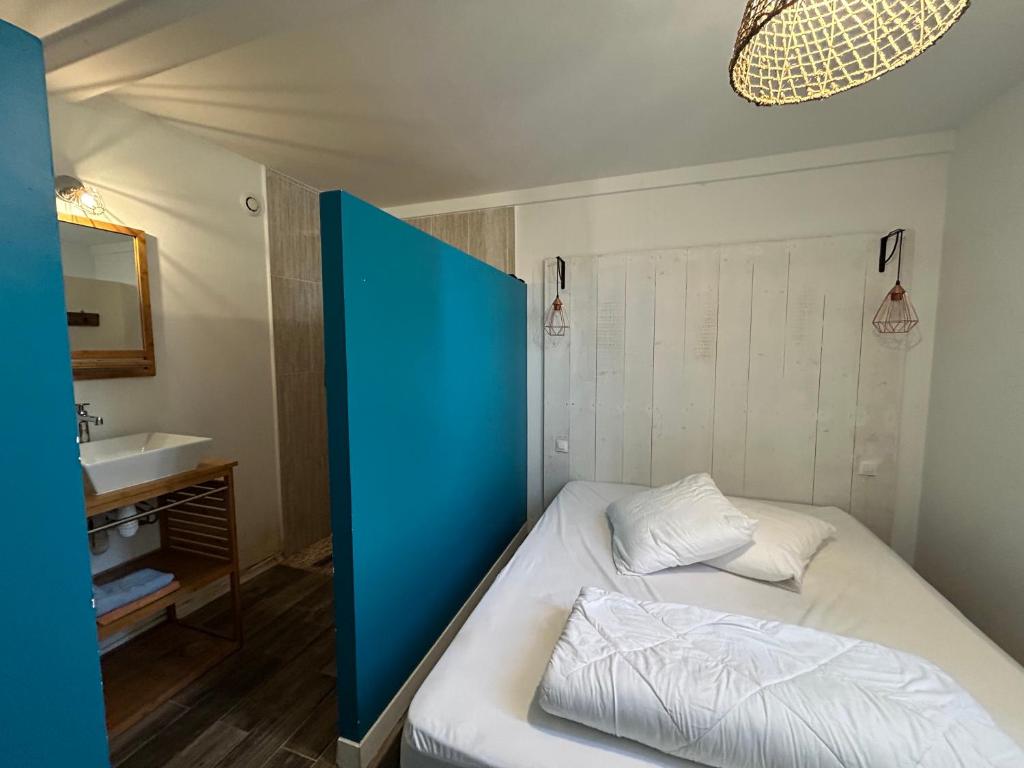 une petite chambre avec un lit et un lavabo dans l'établissement L'Arcachonnaise, à La Teste-de-Buch