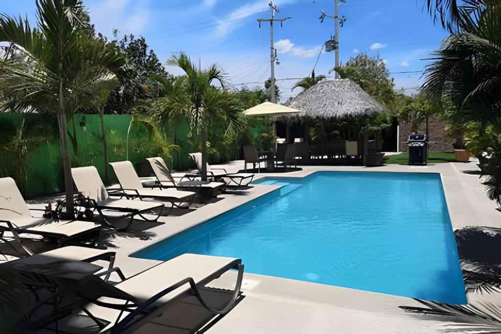 ein Pool mit Chaiselongue und ein Resort in der Unterkunft Departamento Hanna #7 Bucerias in Bucerías