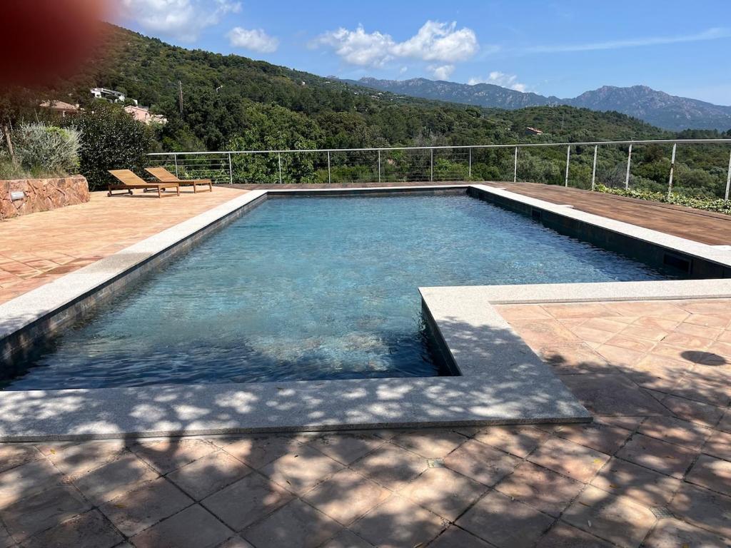 une piscine avec vue sur les montagnes dans l'établissement T2 dans villa avec piscine, à Porto-Vecchio