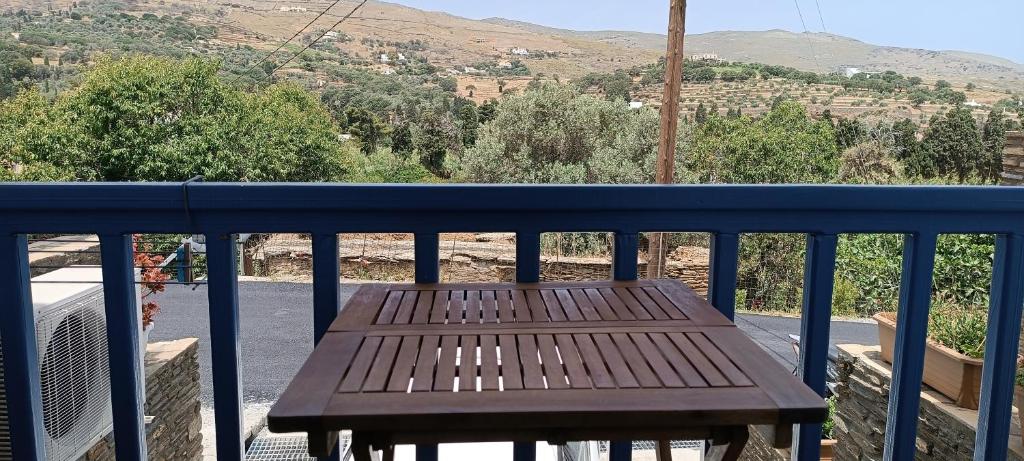 a wooden bench sitting on top of a balcony at Andros Guesthouses in Andros