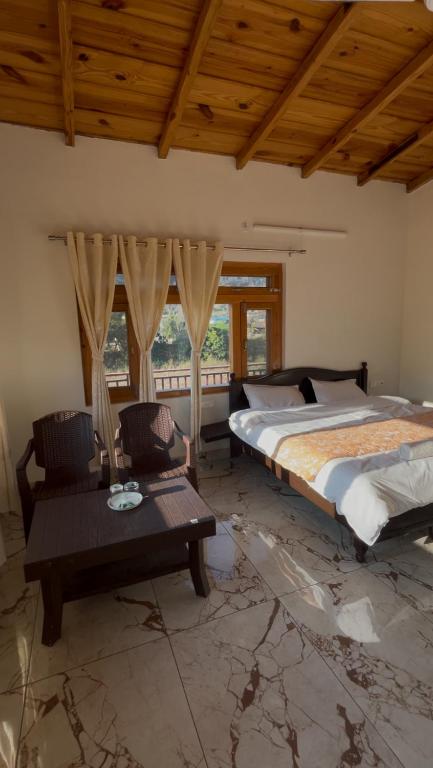 a bedroom with a bed and a couch and a table at Lotus Lake View Inn in Bhīm Tāl