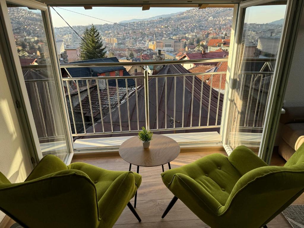 a room with two chairs and a table and a large window at Apartments HAN 2 Sarajevo in Sarajevo
