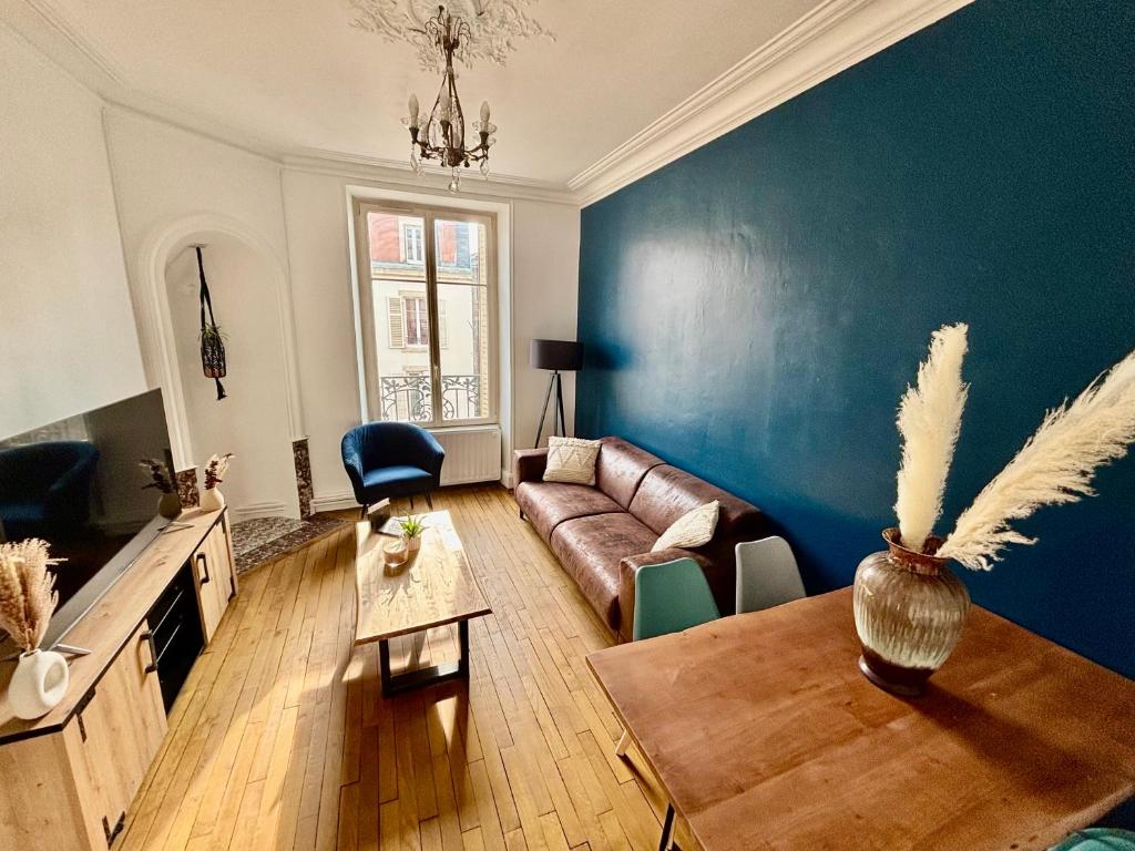un salon avec un canapé et un mur bleu dans l'établissement Apparemment chaleureux hyper centre Nancy, à Nancy