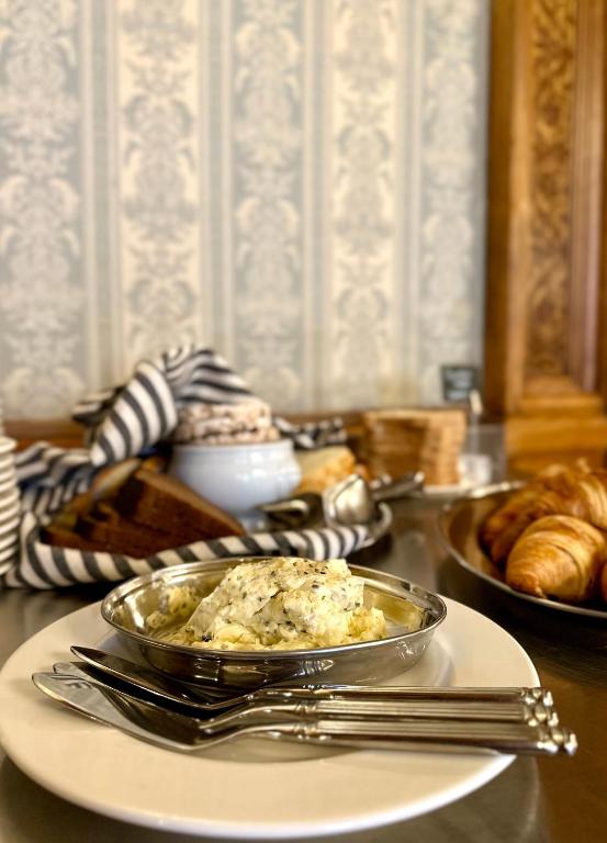 a table with a bowl of food on a plate at The Benjamin House in Rīga