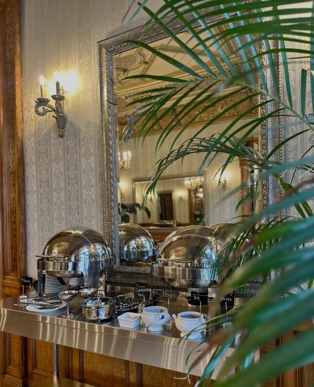 a counter with dishes in front of a mirror at The Benjamin House in Rīga