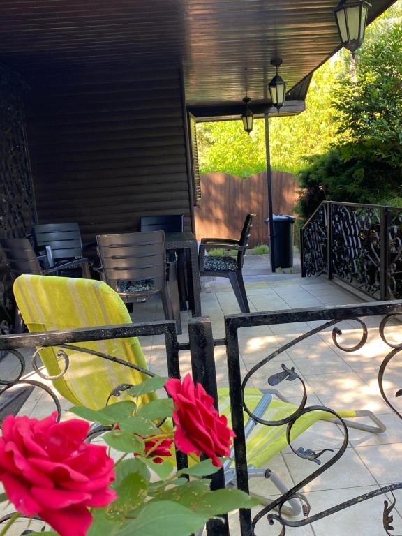 a patio with two chairs and a table with red roses at Romantic bungalow in Balatonudvari