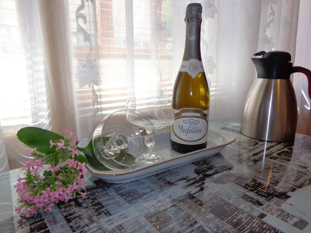 una botella de champán y copas en una mesa en Zoya Apartment, en Burgas