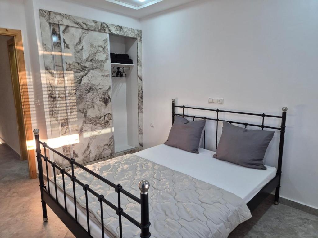 ein Schlafzimmer mit einem Bett mit einem schwarzen Metallrahmen in der Unterkunft Saïdia Residence A - à 7 min de la plage in Saidia 