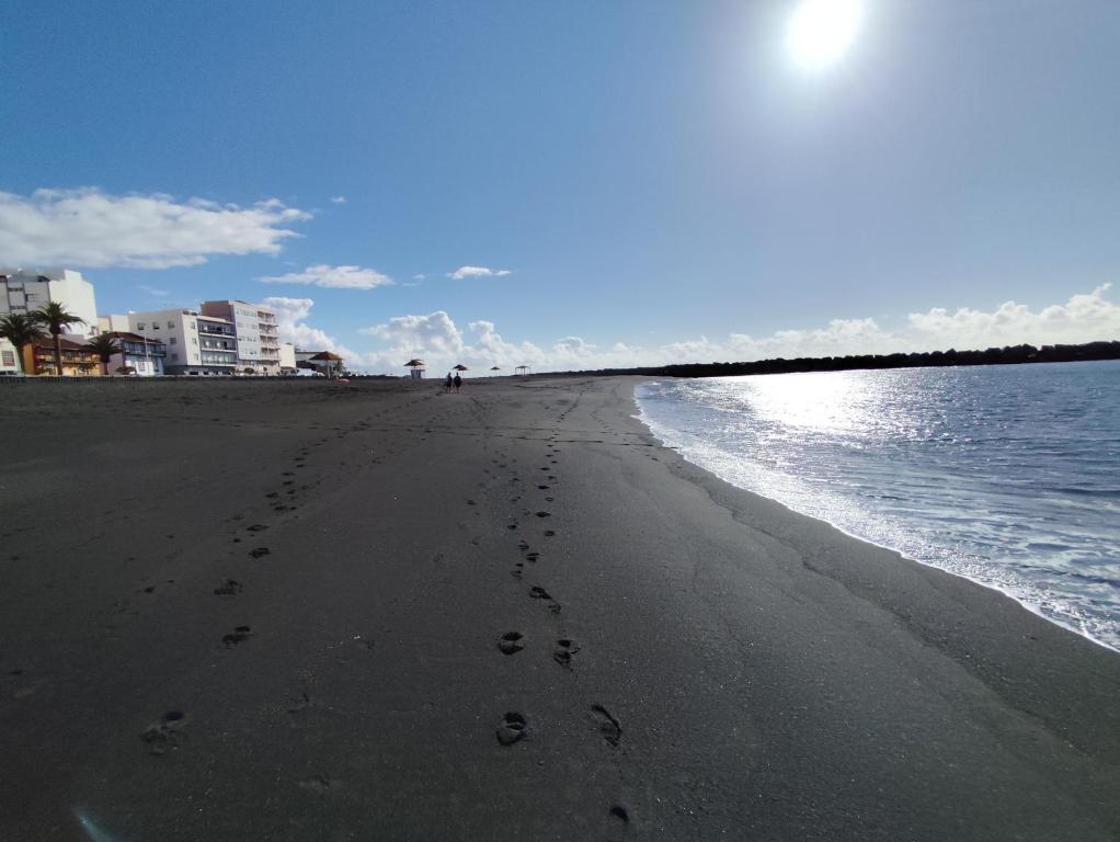 una playa con huellas en la arena y el agua en Dúplex Casa Nerea, en Santa Cruz de la Palma