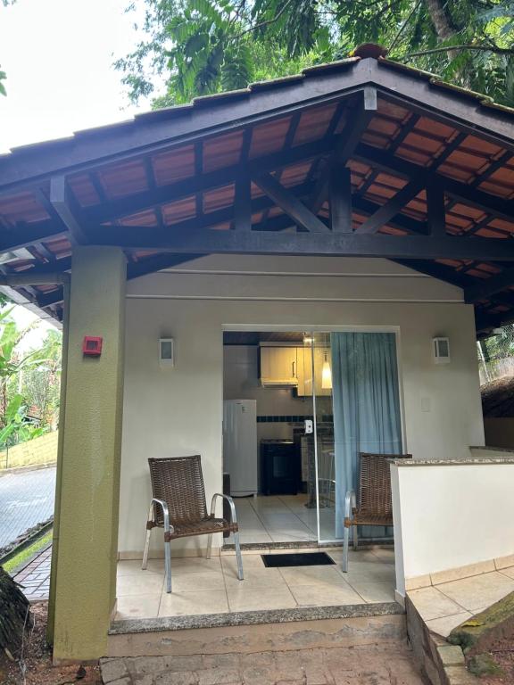 a pergola over a patio with two chairs at Chalé Blumenau in Blumenau