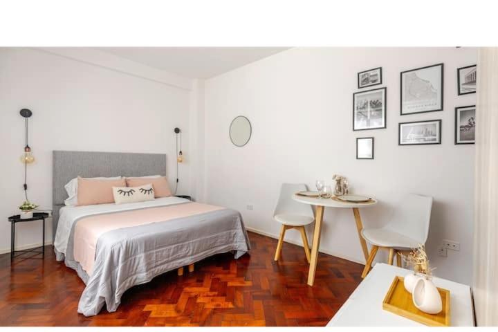 a bedroom with a bed and a table with chairs at Buenos Aires pleno centro, a pasos del Obelisco in Buenos Aires