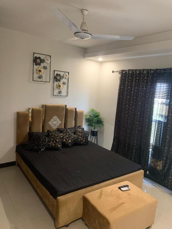 a bedroom with a large bed with a black blanket at Subleasing Pakistan in Rawalpindi