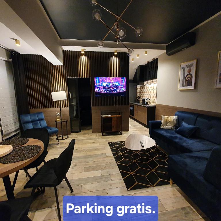 un soggiorno con divani blu e TV a schermo piatto di Apartamenty Kąpielowa Złoty a Ełk