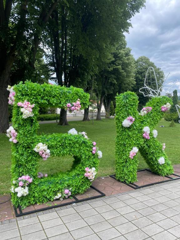 ein mit Blumen geschmücktes Heckenschild in einem Park in der Unterkunft Studio Carobna Dunja in Banja Koviljača
