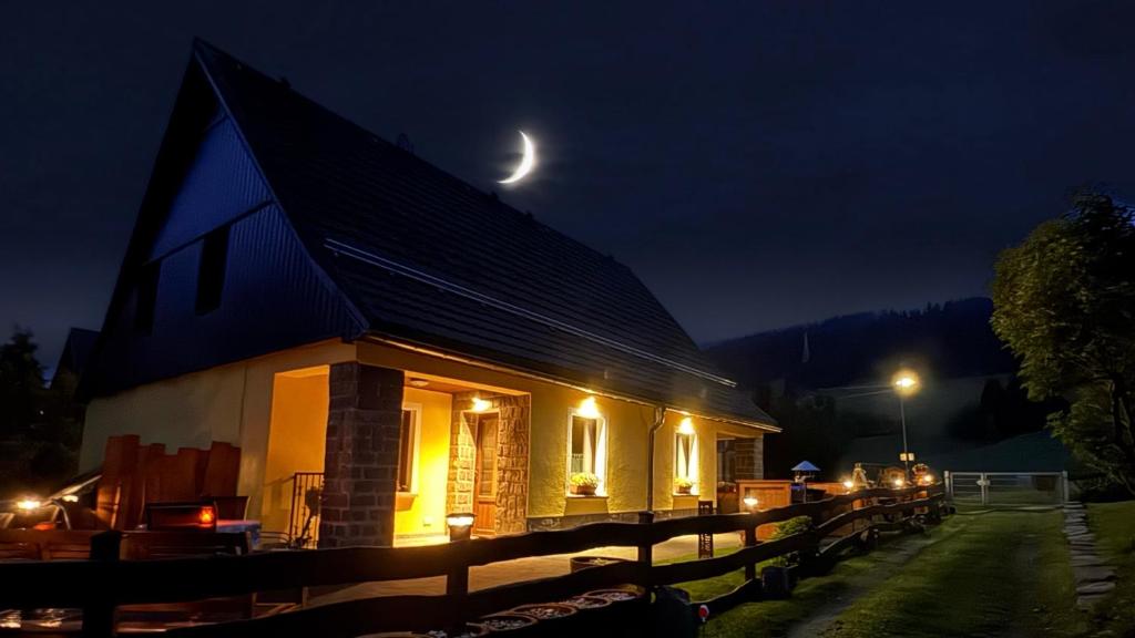 a building with a moon above it at night at Ferienwohnung-direkt-am-Skihang mit Sauna in Kurort Oberwiesenthal