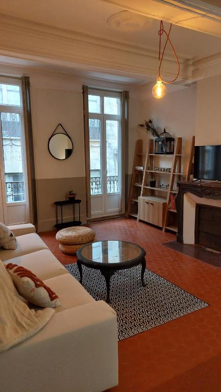 un salon avec un canapé blanc et une table basse dans l'établissement Appartement calme à 100m des Allées Paul Riquet, à Béziers