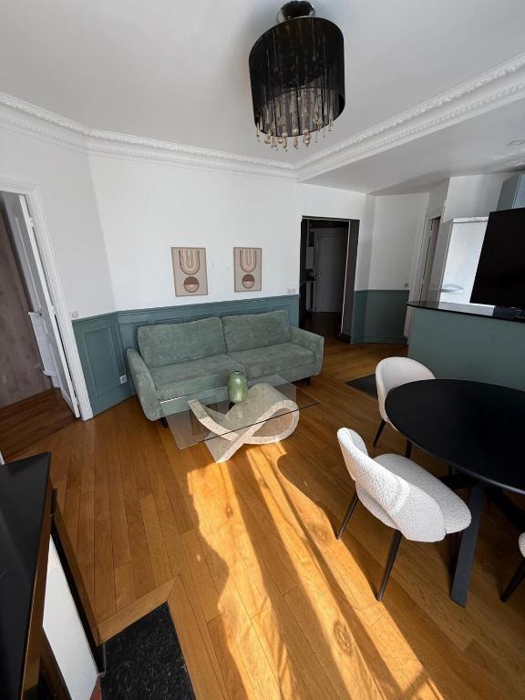 un salon avec un canapé vert et une table dans l'établissement Séjour à Paris, à Aubervilliers