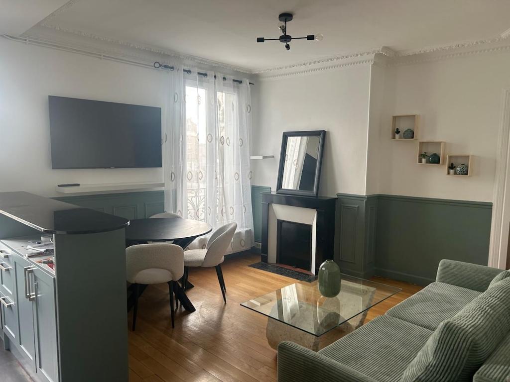 ein Wohnzimmer mit Sofa und Tisch in der Unterkunft Séjour à Paris in Aubervilliers