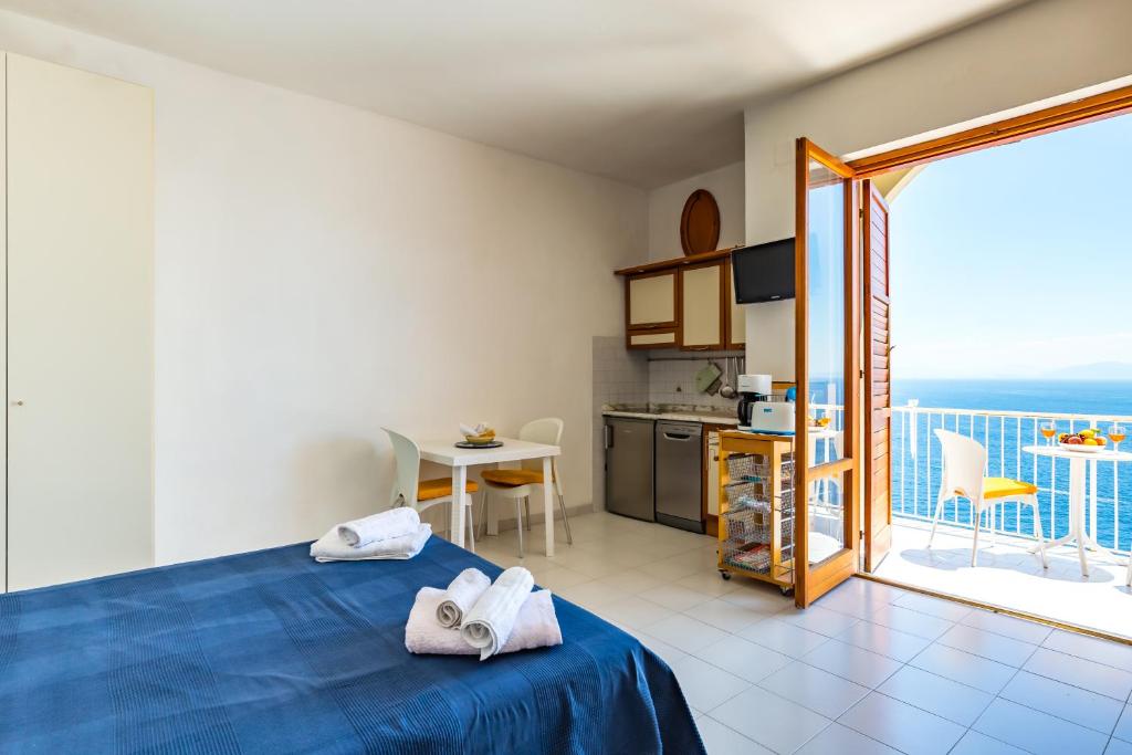 Una habitación con una cama y una cocina y un balcón. en Blue residence, en Amalfi