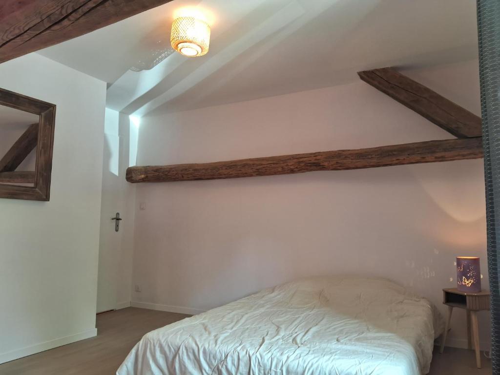 a bedroom with a bed and a cross on the wall at Le 46 pour 2 personnes in Crots