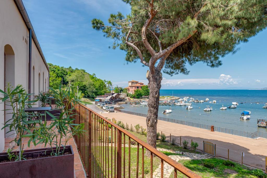 a balcony with a tree and a marina at Porto Baratti Residence in Baratti