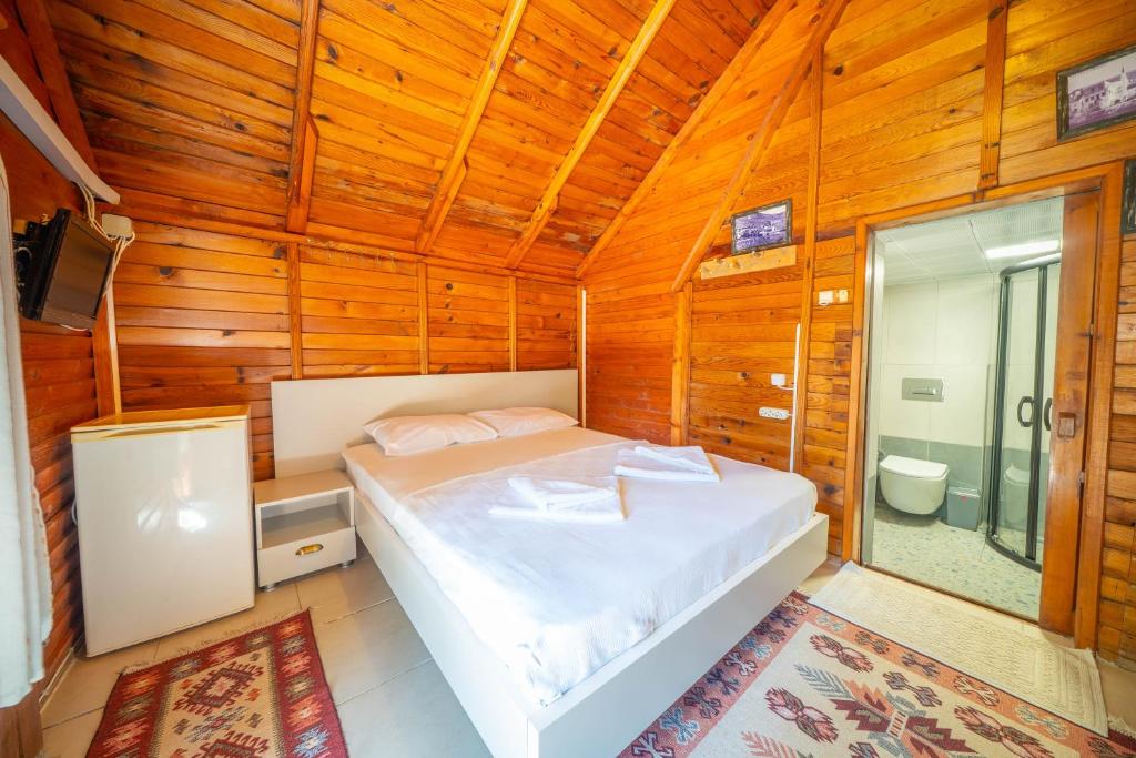 a bedroom with a bed in a wooden cabin at Olympos Mocamp in Kaş